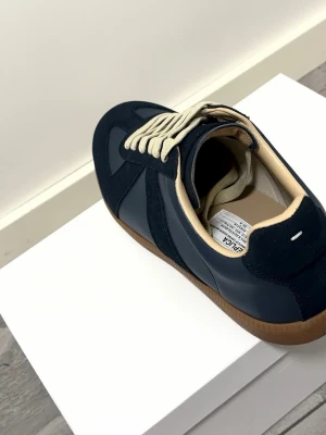 maison margiela - Maison Margiela blåa sneakers – mycket fint skick          Säljer mina blåa Maison Margiela-skor. Nypris är cirka 7 000 kr. Skorna är i princip nya då jag har fått dom i present och Säljes eftersom de inte kommer till användning längre. Dust bag och låda förljer med. Pris kan diskuteras 