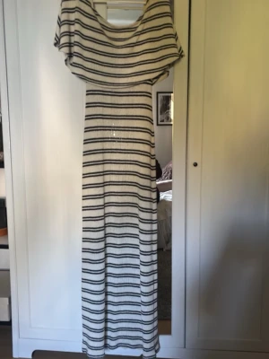 Randig långklänning med off shoulder - Randig ”stickad” klänning från Gina 