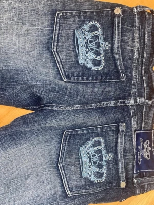 Victoria Beckham jeans - Säljer ett par blå Victoria Beckham jeans i en rak/bootcut modell. På bakfickorna finns broderade kronor med små kristaller i ljusblått som ger en unik touch. 💙 midjemåttet är 36cm och innerbenslängden är ca 80cm. 