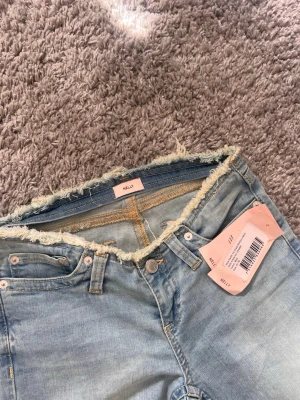 Ljusblå bootcut jeans från Nelly - Säljer ett par ljusblå bootcut jeans från Nelly som är helt nya med prislappen kvar. Dem är sjukt snygga och Perfekta för en trendig och avslappnad stil.