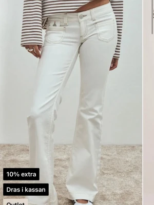 Super low heart pocket bootcut jeans  - Supersnygga vita jeans från Nelly. Säljes då dom tyvärr är lite små och där med inte kommer till användning. Dom är bara använda ett fåtal gånger men har en liten defekt på höger ben, se sista bilden, men det är ingen man tänker på. Dom är även i short och passar mig som är 163cm. Helt slutsålda på hemsidan!💗 Nypris: 700kr