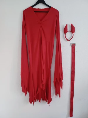 Red devil costume  - Fire red devil-inspired dress with dramatic flaming long sleeves and hem. Features a high slit and comes with a matching fabric belt and devil horns. Flexible, lightweight material with a comfortable fit.  Size: XS ( suitable from XS-M) Condition: Very good Colour: Red Material: Polyester  Measurements: • Dress length: 130 cm • Bust: max 100 cm • Waist: max 90 cm  Perfect for Halloween, costume parties, themed events, festivals or other occasions. 😈🔥