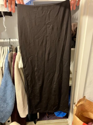 Svart lång tight kjol - En svart, lång och tight kjol i stretchigt material. Kjolen har en enkel och stilren design!