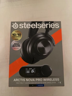 SteelSeries Arctis Nova Pro Wireless - Säljer ett par SteelSeries Arctis Nova Pro Wireless gaminghörlurar i svart med aktiv brusreducering och multi-system receiver. Grym ljudkvalitet, trådlös anslutning och dedikerad kontrollstation med display för enkel hantering. Perfekt för PC och Playstation.