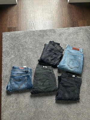 Dondup jeans - Säljer fem par jeans i olika tvättar och färger, både blå och svarta. Några har klassiska femficksdetaljer och synliga loggor på bakfickan. Perfekta för dig som vill ha variation i garderoben och gillar både ljusa och mörka jeans.