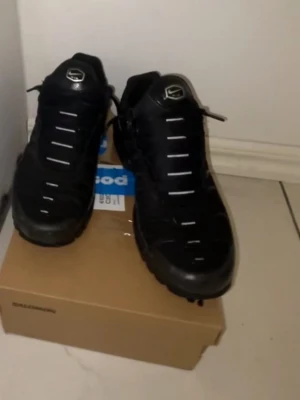 Nike tn  - Säljer ett par svarta chunky sneakers med vita detaljer på snörningen. Skorna har en robust sula och sportig design, perfekta för dig som gillar streetwear och vill ha en cool look. Materialet ser ut att vara en mix av textil och syntet. Finns mer bilder om det finns intresse 