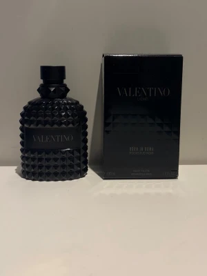 Valentino Uomo Born In Roma Rockstud Noir 70ml kvar - Valentino Uomo Born In Roma Rockstud Noir är en parfym i en cool svart flaska med nitar och matchande svart kartong. Flaskan har en unik, rockig design och rymmer 100 ml eau de toilette. Perfekt för dig som gillar exklusiva och stilrena dofter. 