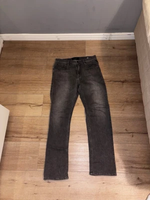 Grå raka jeans från Replay - Snygga grå jeans från Replay med raka ben och klassisk femficksmodell. Jeansen har coola detaljer på bakfickorna och är tillverkade i mjukt denimtyg. Perfekta för en avslappnad och trendig look.