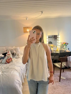 Vit halterneck topp med knyt - Säljer en champagnefärgad halterneck topp med snygg knytning i nacken och öppen rygg. Aldrig använd💗