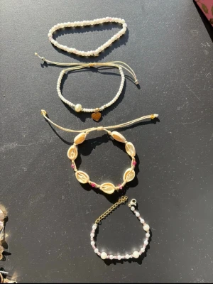Set med pärlarmband och snäckarmband - Säljer dessa då dom ej används och är knappt använda så kändes onödigt att slänga. Säljer flera fina guld smycken och billiga kläder, köp gärna bundle för bundle-rabatter!💞💞💞