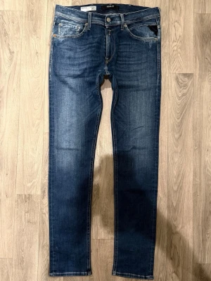 Replay Jondrill Hyperflex Jeans Blå W33/L32 - Slim/Skinny Fit - Replay Jondrill Hyperflex blå jeans med slim/skinny fit-passform som sitter smalt och bekvämt och funkar till allt, storlek W33/L32, midja 42 cm, ytterbenslängd 108 cm, benöppning 16,5 cm, modellen är 185cm & väger 65kg, i fint skick.