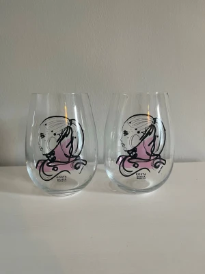Kosta Boda - All About You - Tumblerglas - 57cl - 2-pack - Love You - Säljer ett 2-pack tumblerglas från Kosta Bodas populära serie All About You, formgiven av Sara Woodrow. Glasen har det rosa motivet ”Love You” och en elegant, feminin design! Antal: 2 st. Handtillverkade. Material: Glas. Volym: 57 cl. Storlek: Höjd 12,3 cm. Diameter 9 cm. Säljs i nytt och oanvänt skick! Originalförpackning ingår! Kika gärna in på mina andra annonser, just nu säljer jag 4 ytterligare glas ur samma serie! Så passa gärna på medan de finns! Hör gärna av dig vid frågor och intresse!