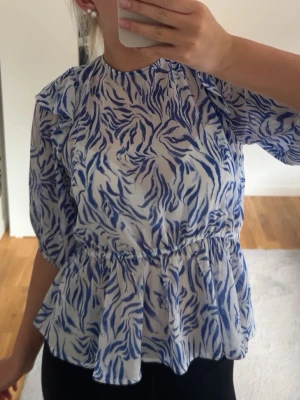 Blåvit mönstrad blus med volang - Säljer min fina Kappahl blus då den aldrig kommer till användning! 🩵