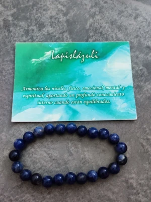 Blått armband med lapis lazuli-pärlor - Snyggt armband med runda, djupblå pärlor av äkta lapis lazuli. Pärlorna är trädda på en elastisk tråd som gör att armbandet passar de flesta handleder. Perfekt accessoar för dig som gillar stilrena och naturliga smycken.