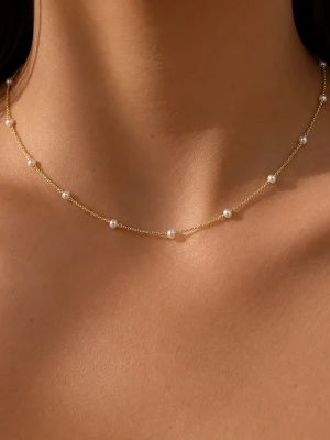 Guldhalsband med små pärlor - Säljer ett tunt och elegant halsband i guldton med små vita pärlor jämnt fördelade längs kedjan. Halsbandet har en minimalistisk och stilren design som passar perfekt för dig som gillar subtila smycken.