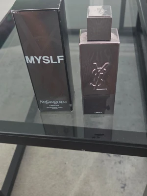Yves Saint Laurent  MYSLF L'Absolu 100ml - Säljer en elegant parfym från Yves Saint Laurent, modellen MYSLF L'Absolu. Flaskan är mörk och stilren med YSL-loggan i silver på framsidan och har en fyrkantig form. Kommer i originalförpackning. Perfekt för dig som gillar exklusiva dofter. Mängd nästintill oanvänd