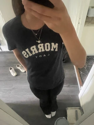 Mörkblå Morris Lady t-shirt - Säljer en mörkblå t-shirt från Morris Lady med vit text framtill. Klassisk rund halsringning och korta ärmar. Skön passform och tillverkad i mjuk bomull, perfekt till jeans eller shorts.