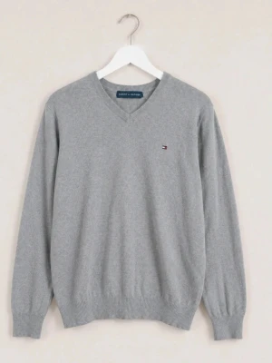 Grå V-ringad tröja Tommy Hilfiger - Klassisk grå V-ringad tröja från Tommy Hilfiger med diskret logga broderad på bröstet. Tröjan har ribbade muddar vid ärmslut och nederkant, perfekt för lager på lager och enkel att matcha till olika outfits.