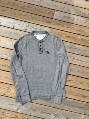 Vintage 2000s Abercrombie & Fitch henley  - Säljer denna Vintage 2000s Abercrombie & Fitch henley i modellen Muscle, inga defekter! Storlek L. Kontrollera måtten innan ni köper! Hör av er vid frågor eller minsta fundering 🙌  Se mått nedan:  Längd: 73 cm  Bred: 51,5 cm  Ärm: 75 cm