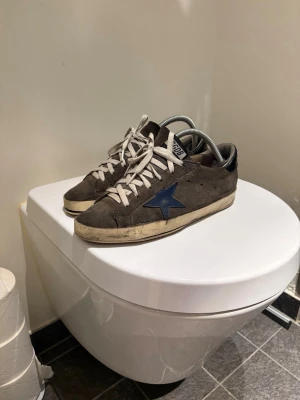  Golden goose   -  Säljer ett par fina golden goose I Mocka. Skorna passar till allting och mockan är fortfarande mjuk. Plastkanterna har gått upp lite på vissa ställen  Men inget som går igenom in till skon. Tveka inte Om ni undrar nåt mvh Einar 