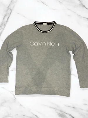 En Grå Calvin Klein långärmad tröja 👕  - En riktigt fin och skön Calvin Klein tröja 👕 den sitter riktigt bra på kroppen👍 priset är ej hugget i sten så kom med bud🤝