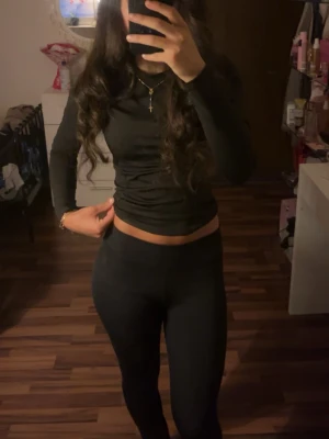 Svarta raka leggings - Säljer ett par svarta leggings med hög midja och tight passform. De är stretchiga och sitter skönt mot kroppen, perfekta för en trendig och enkel look. Materialet ser ut att vara mjukt och följsamt, vilket gör dem bekväma att bära hela dagen.