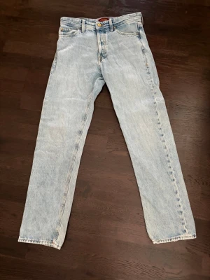 Ljusblå raka Jack&Jones jeans - Säljer ett par klassiska ljusblå Jack&Jones jeans med rak passform och hög midja. Originalpris 600kr med bra skick. Storlek 28/32