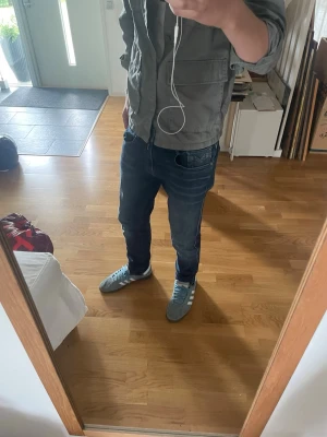 Mörkblå slim fit jeans herr - Säljer ett par mörkblå slim fit jeans med klassisk femficksdesign och kontrastsömmar. Jeansen har normal midja och smal passform hela vägen ner. Perfekta till sneakers och vardagsstil. Materialet är denim i bomull.