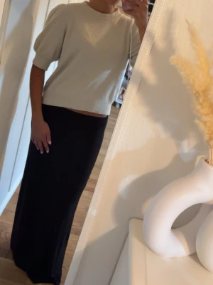 Beige stickad tröja med puffärm - Beige stickad tröja med puffiga halvlånga ärmar och rund halsringning. 