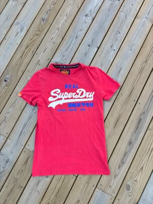 Superdry t shirt ~ Vintage  - Säljer denna Superdry t shirt i mycket bra skick och som är Vintage. Storlek S. Passar perfekt för dig som är mellan 175-180! Hör av er vid frågor eller minsta fundering 🙌  Längd: 68 cm  Bred: 43 cm  Ärm: 17 cm