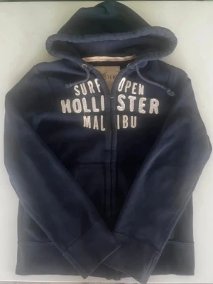Hollister Malibu Hoodie - Snygg Hollister Malibu hoodie i mycket fint skick. Storlek M. Kan självklart skicka mått vid intresse. Priset är 499 kr, men det går att diskutera vid en smidig affär. Hör gärna av dig om du har frågor eller vill lägga ett bud.