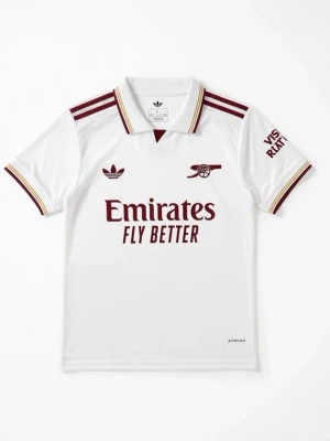 Vit Arsenal matchtröja Adidas - Snygg vit Arsenal matchtröja från Adidas med vinröda detaljer och klubbmärke på bröstet. Tröjan har korta ärmar, krage med ränder och trycket 'Emirates Fly Better' på framsidan. På ryggen står det EZE och nummer 10 i svart.