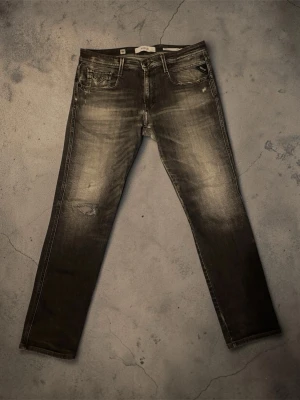 Replay jeans med slitningar  - Snygga svarta slim fit jeans med slitningar och tvättade detaljer på låren och knäna. Klassisk femficksmodell med dragkedja och knapp i midjan. Jeansen har en modern, smal passform och är tillverkade i denim. Skriv vid eventuella frågor, pris ej huggsten