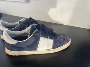Blå och vita låga sneakers - Säljer ett par valentinos i storleken 46. Skorna är i hyfsat skick och sitter bra på foten. Det saknas två taggar och är rättså slitna. Annars bra skick. 