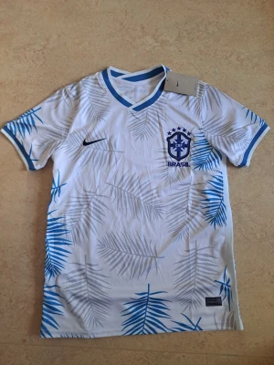 Brasilien fotbollströja  - Helt ny med prislappar. Den har dock någon liten fläck på backsidan av tröjan som man kan tvätta bort.
