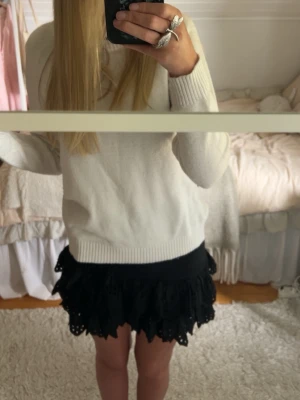 Svart volangkjol med broderade detaljer - Supersöt svart kortkjol med volanger och broderade detaljer. Den har endast används en gång i och med att den är lite för liten för mig i midjan. Det finns en dragkedja och jag skulle säga att det gör att den passar mindre storlekar såsom xs/xxs. Kjolen går ganska högt upp i midjan och därmed tycker jag att den passar perfekt med slags stickad tröja över!!💕