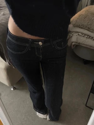 Ginatricot jeans - Trendiga Lågmidjade bootcutjeans i mörkblå med vita sömmar, strl 32