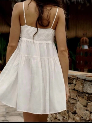 Vit kort sommarklänning med smock - Söt vit kort klänning från ZARA, storlek XS. Det en liten fläck som knappt syns kan skicka bild på det, ska se ifall det går bort