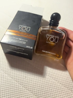 Emporio Armani Stronger With You Intensely - Emporio Armani Stronger With You Intensely är en herrparfym med varm, amberfärgad vätska i en stilren, fyrkantig glasflaska med svart rund kork. Förpackningen är svart med guldiga detaljer och text. En modern och intensiv doft för dig som vill sticka ut.