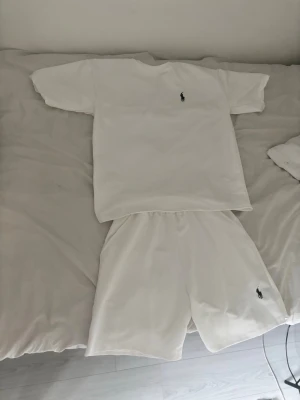 Vita shorts och vit T-shirt från Polo Ralph Lauren - Säljer ett par klassiska vita shorts och en klassisk vit t shirt från Polo Ralph Lauren. Shortsen och T shirten är bekväma och fräscha. Jag själv är 170cm lång och dom passar bra, så storleken S är för dig som är mellan 165-170cm lång. Shortsen är lite tighta där uppe med sitter annars bra och är väldigt bekväma. Har du någon fråga är det bara att skriva till mig eller vill ha fler bilder. Har aldrig använt settet.