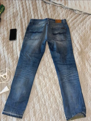 Nudie jeans blå - Säljer detta sjukt nudie jeans i storlek 32/32, men sitter som 32/30.. säljaren är 185 och väger 83kg så det har tyvärr blivit så små för honom..