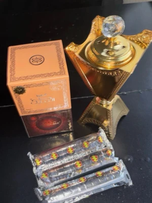 Oudh bakhoor orientalisk rökelse - Säljer ett exklusivt parfymset med Oudh Nasamat, innehållande en dekorativ guld- och kristallfärgad rökelsebrännare, en elegant förpackning och flera inslagna rökelsestickor. Perfekt för dig som gillar orientaliska dofter och vill ha en lyxig känsla i hemmet.