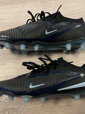 Nike phantom 6 elite low - Nike phantom 6 elite low. Skorna har en strumpliknande passform, snörning och mönstrad ovandel i textil och syntet. Sulan har fasta dobbar för spel på gräs. Perfekta för dig som vill ha stil och grepp på planen.