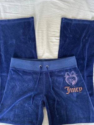 Mörkblå Juicy Couture byxor  - Mörkblå Juicy Couture byxor. Storlek 14 i lappen men passar XXS/XS.  Midjemått tvärsöver: 34 cm. Innerbenslängd: 74 cm.