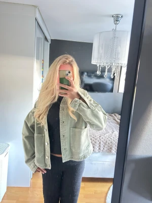 Oversized ljusgrön jeansjacka - Säljer en oversized ljusgrön jeansjacka med klassisk krage och stora framfickor. Jackan har knäppning framtill och en avslappnad passform som ger en cool och trendig look. Perfekt att slänga över en hoodie eller t-shirt för en casual vibe. 
