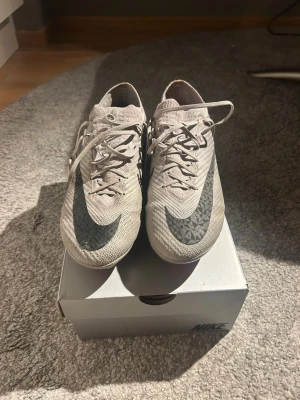 Beige Nike fotbollsskor med svart swoosh - Nike fotbollsskor i bra skick använda ett fåtal gånger men har så många skor så kommer inte till användning 