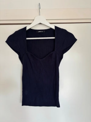 Blå Gina Tricot topp - En fin marinblå topp från Gina Tricot med urringning. Använd fåtal gånger. 