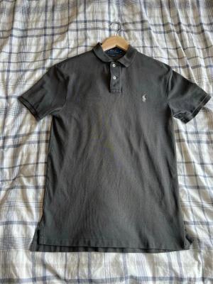 Polo Ralph Lauren pikétröja – Grå – M (Slim Fit) - Säljer en stilren grå Polo Ralph Lauren pikétröja i storlek M (Slim Fit). Tröjan är använd men fortfarande i fint skick utan större anmärkningar. Klassisk design med vit broderad logga på bröstet – passar både till vardag och lite mer uppklädda tillfällen.  Storlek: M (Slim Fit) Färg: Grå Skick: Använd, fint skick  Skicka gärna ett meddelande vid frågor eller om du vill ha fler bilder!