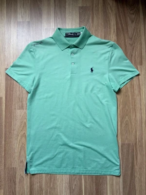 RLX Ralph Lauren ljusgrön golfpiké - storlek S - Fräsch ljusgrön pikétröja från Ralph Lauren med klassisk krage, knappar framtill och broderad logga på bröstet. Har korta ärmar för en clean och stilren look. Funkar lika bra som golf och träningspiké som vanlig vardags piké. Skriv vid frågor!