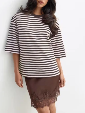 Randig Oversize topp gina tricot ny med lapp  - Oversize topp från gina tricot i storlek M. Toppen är i oversize modell med vida stora T-shirt ärmar. Den är randig. I verkligheten är bilderna jag tagit dom ser ger rättvisast färg. Den är ljus rosa/creme i en brun/vinröd ton. Oanvänd med prislapp kvar. 100% bomull 